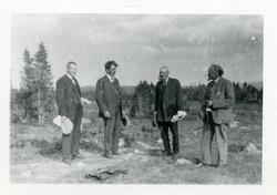Ei gruppe med menn ute i åpent landskap.