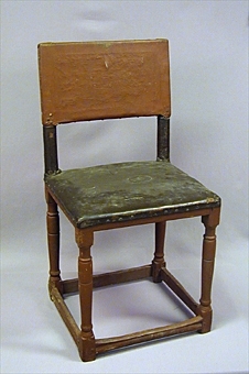 Rödmålad stol av barocktyp med raka profilsvarvade ben och låga tvärslåar.Skinnklädd rygg och ryggstolpar, stoppad och skinnklädd sits.