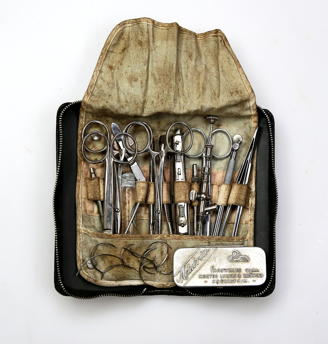 Skinnetui med diverse instrumenter for mindre kirurgiske inngrep og skadebehandling, herunder sakser, kniver, pinsetter, suturnåler, suturtråd, nåleholder, injeksjonsnåler