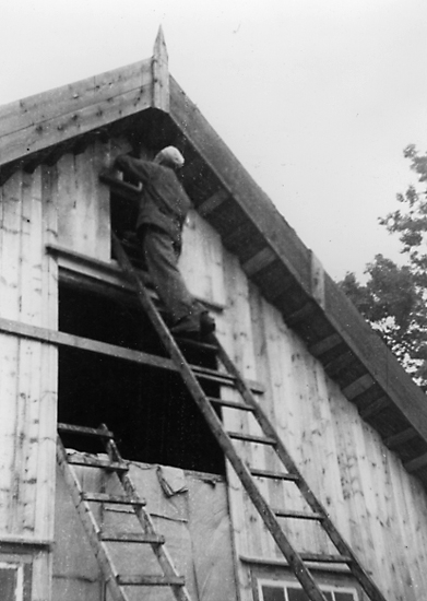 Lars Eriksson sätter in fönster på rännet, Heljesgården.