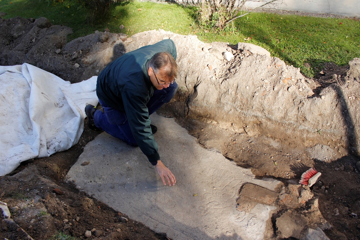 Arkeologisk schaktningsövervakning och undersökning, detaljstudium av runstenens ristning, Hagby kyrka, Hagby socken, Uppland 2016