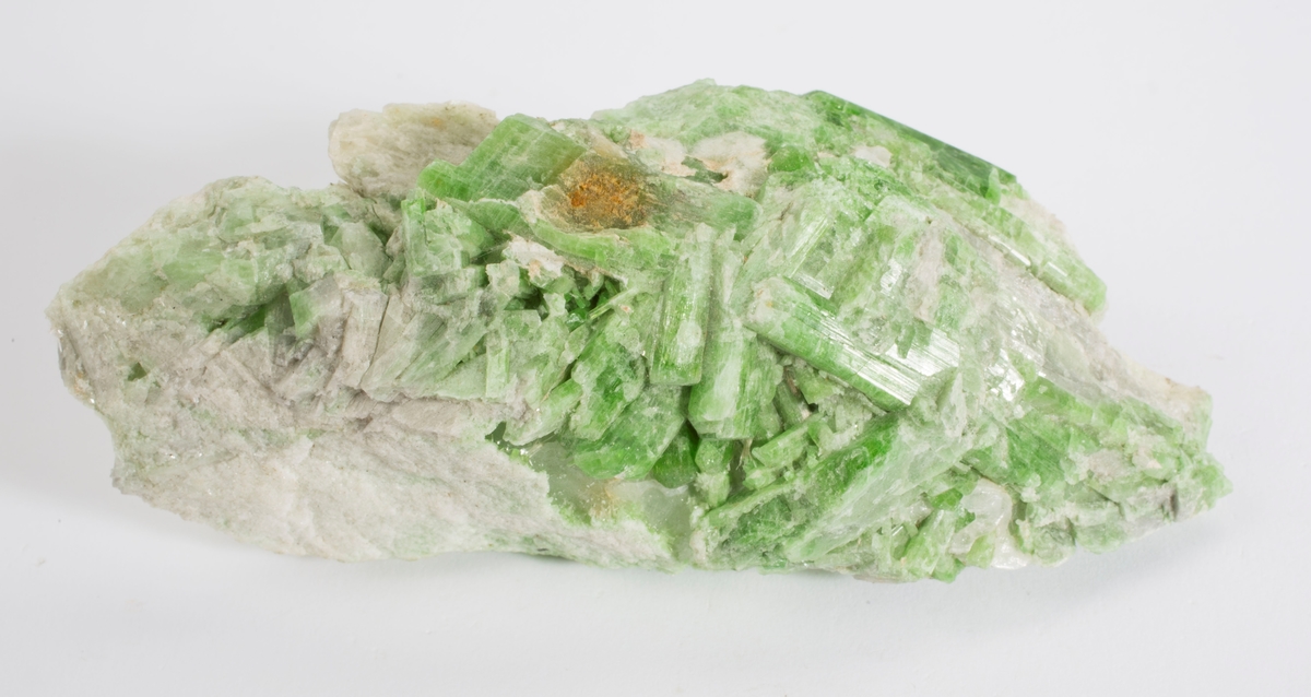 Kromdiopsid, krystaller på matriks, smaragdgrønn.
Finfibrig hvit tremolitt (?), svak fiolett karbonat.