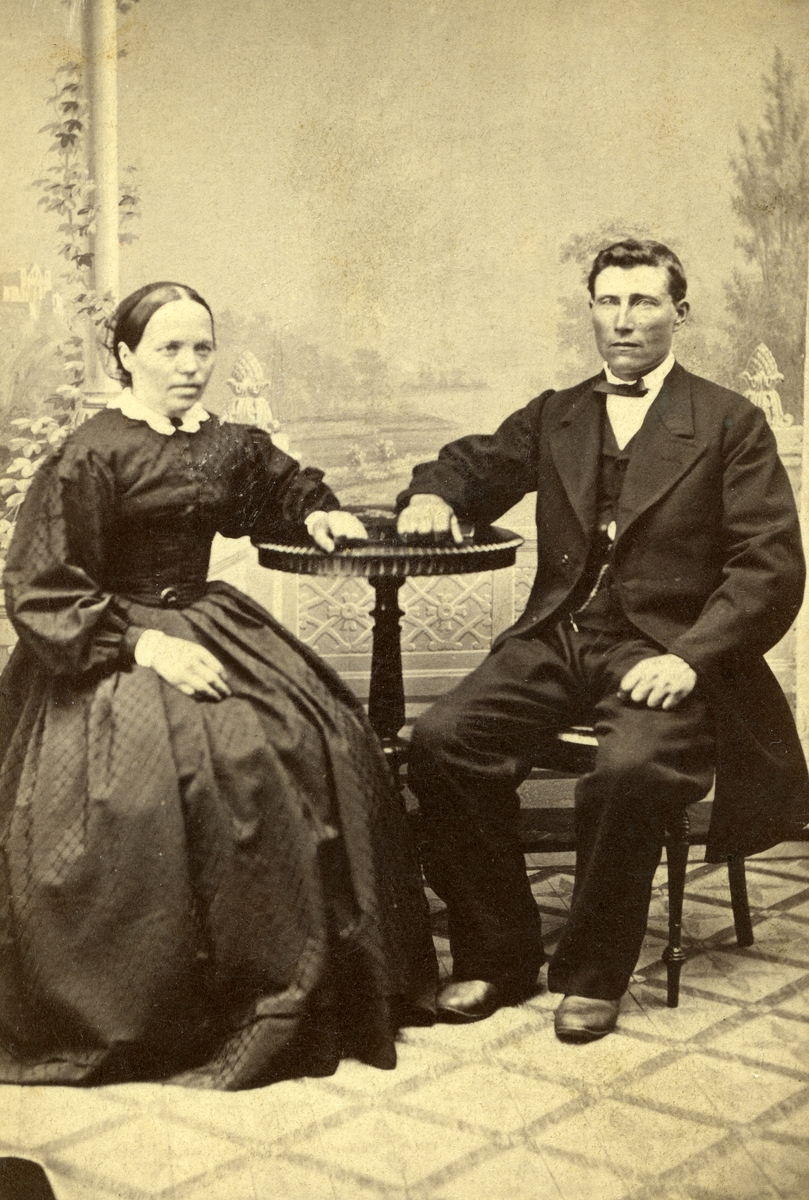 Portrett av (sittende ved bord) Ener Jonsen Østenheden (1826 - 1899) og hustru Berthe Christiansdatter f. Hammeren (1832 - 1910).