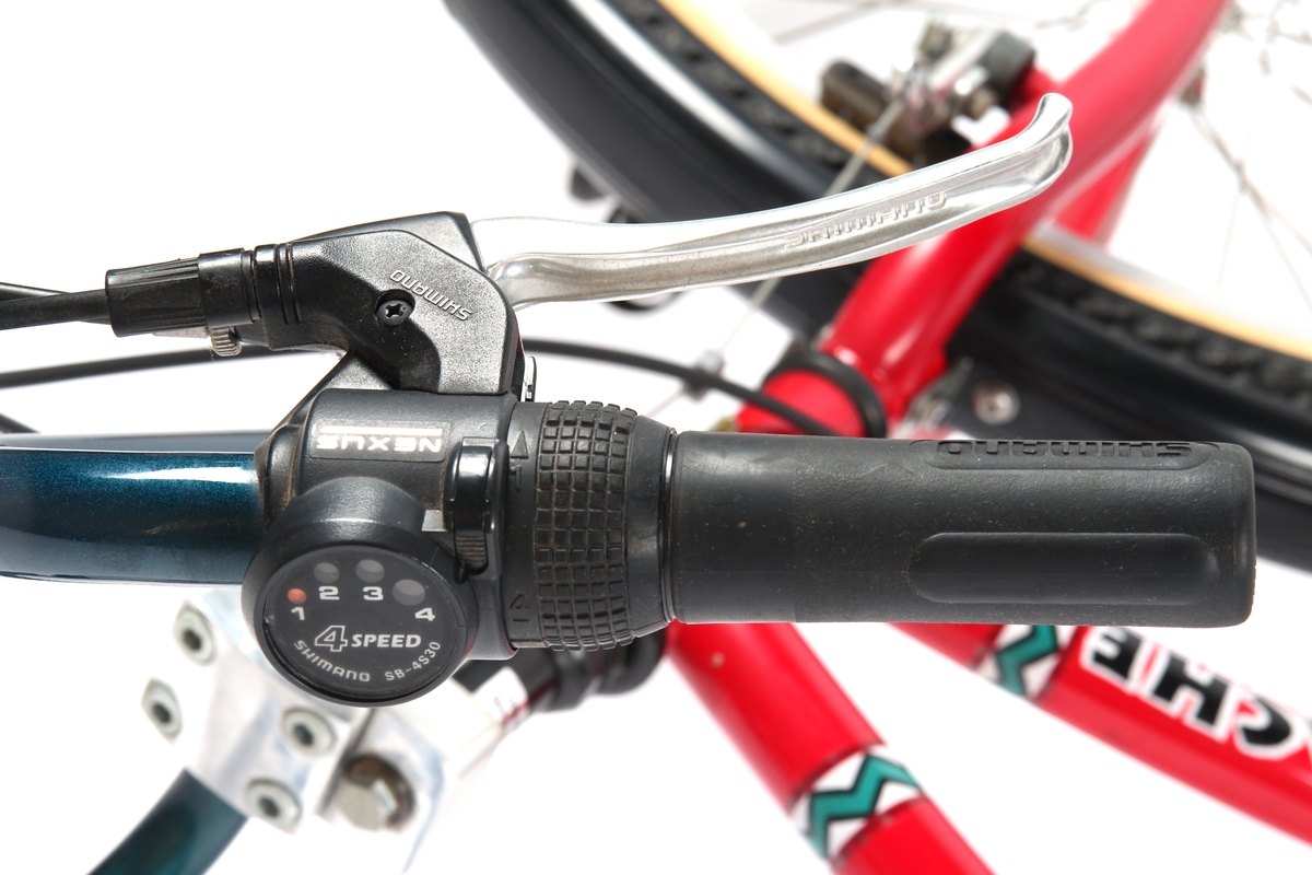 Rødlakkert guttesykkel med Shimano Actus bremsesystem og Shimano girsystem.