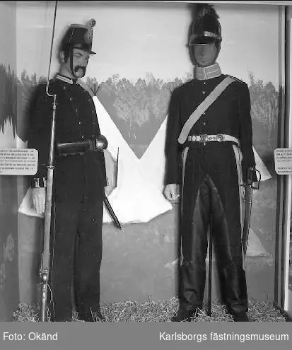 Montrar med uniformer i fästningssalen 1985. Till vänster infanterist från Västgöta regemente i uniform m/1886. Till höger artillerist ur Göta artilleriregemente i uniform m/1815.