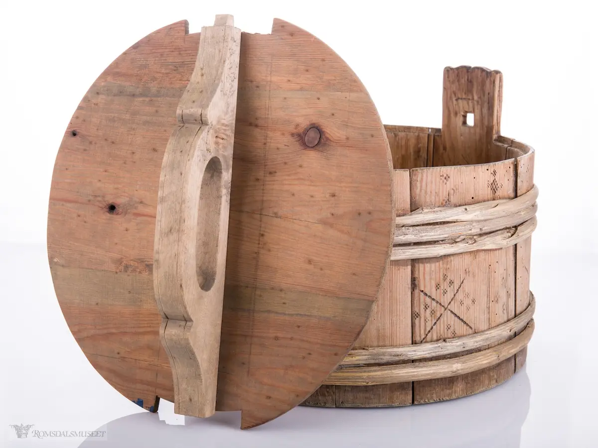 Lagget ambar med ører og lokk med hanke. Omslått med gjorder oppe og nede.