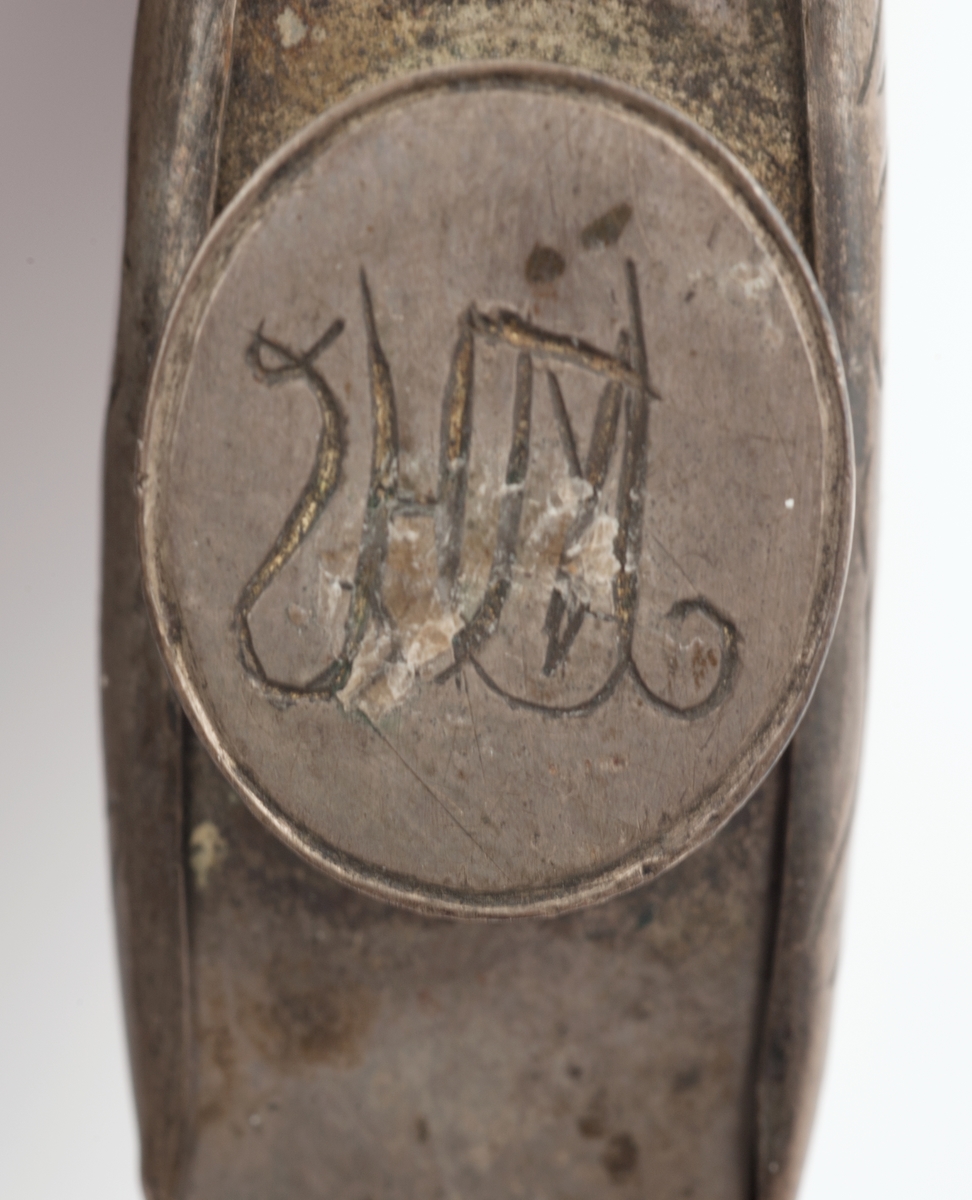 Snushorn av horn med bunn og sidebeslag av tinn. Hornet er dekorert på flatsidene med stiliserte blomsterranker. Munningen er formet som en åpen dragekjeft. Den korteste smalsiden har rankedekor på beslaget.
Bunnen er merket med et uklart monogram.
Hornet er så stort at det kan også ha vært brukt som krutthorn.