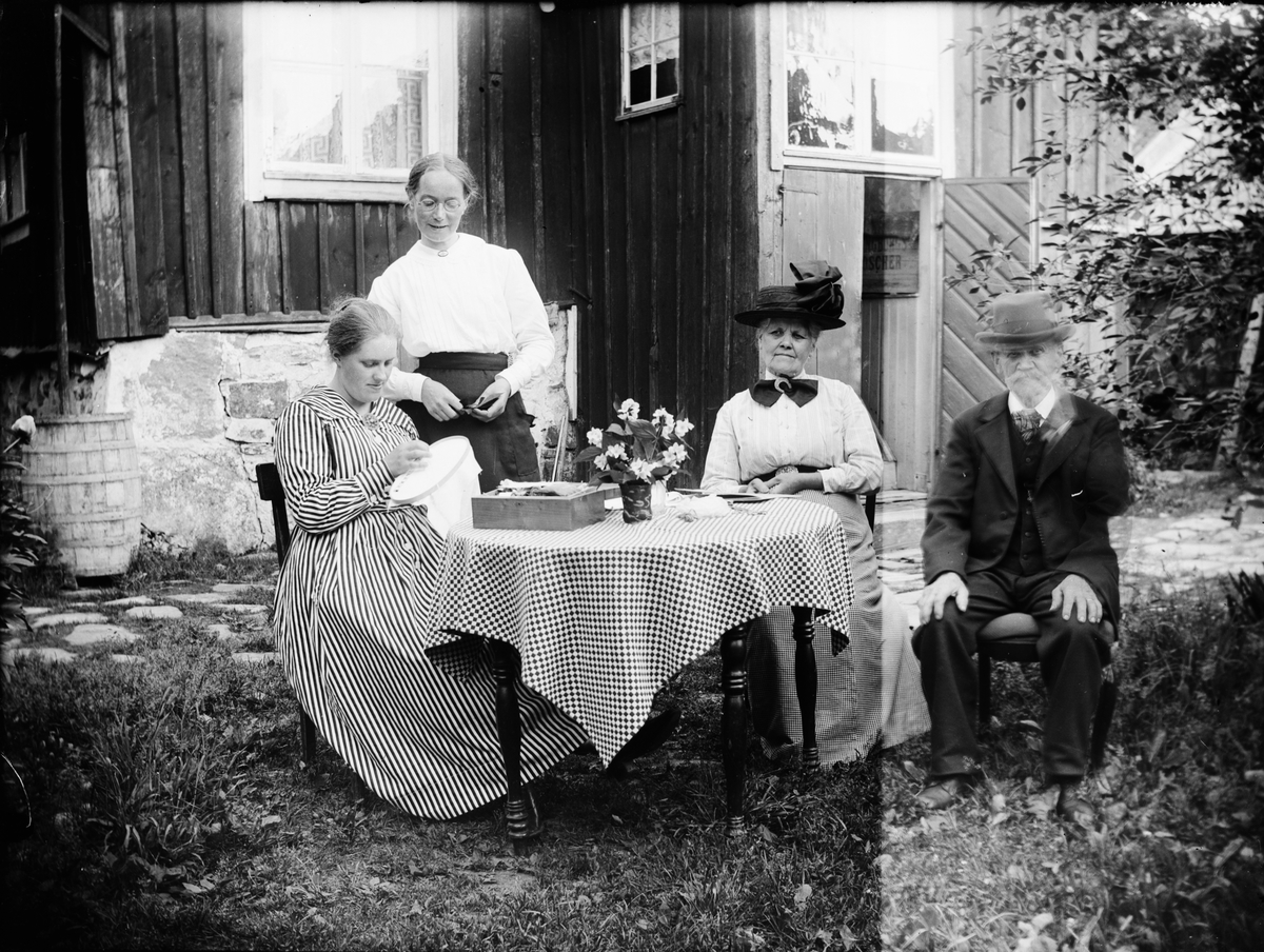 Svarvare Holm och tre kvinnor sitter ute i trädgården, Östhammar, Uppland