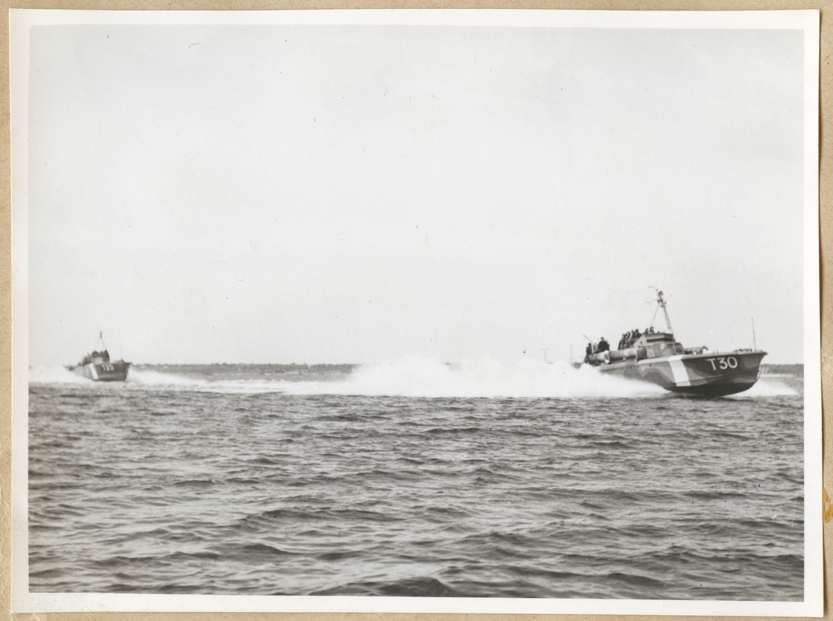 Två motortorpedbåtar färdas i hög hastighet över havet. I täten syns T 30, som senare döptes om till Alex, därefter följer T 25.
