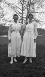 To uidentifiserte kvinner i sommerlige omgivelser.