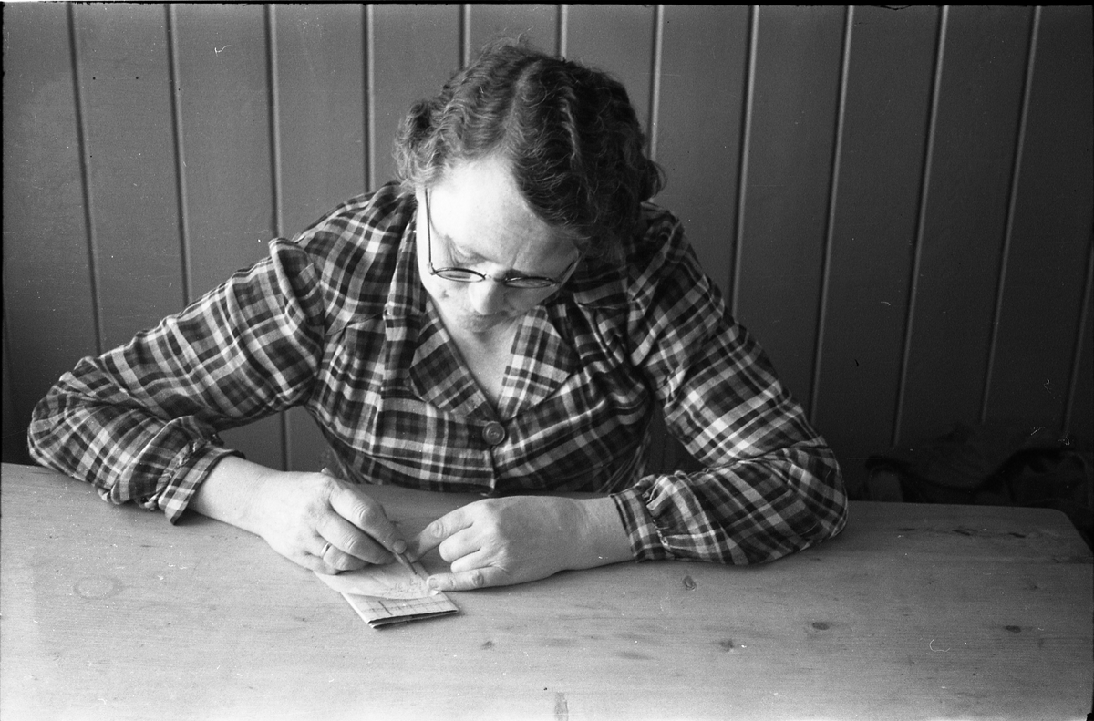 Karine Røisli som sitter ved et bord og skriver.