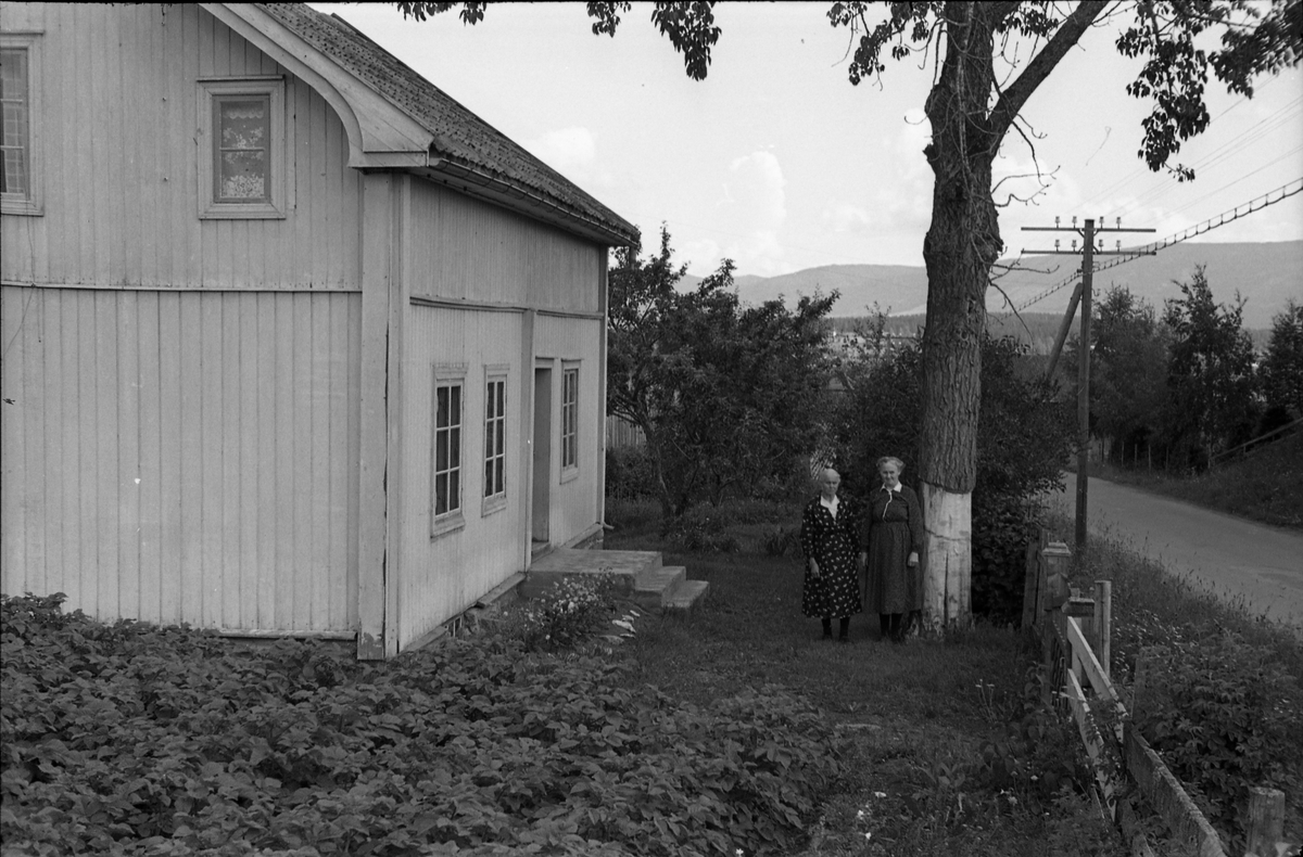 Engeli på Kraby, Østre Toten. Serie på sju bilder. Det første bildet viser våningshuset, likeledes bilde to til fem, men her med to eldre kvinner ved huset. Den ene er Olga Engeli, alene på bildene seks og sju. På bildene to til fem sammen med en annen gammel kvinne som trolig er mora Thea Engeli.