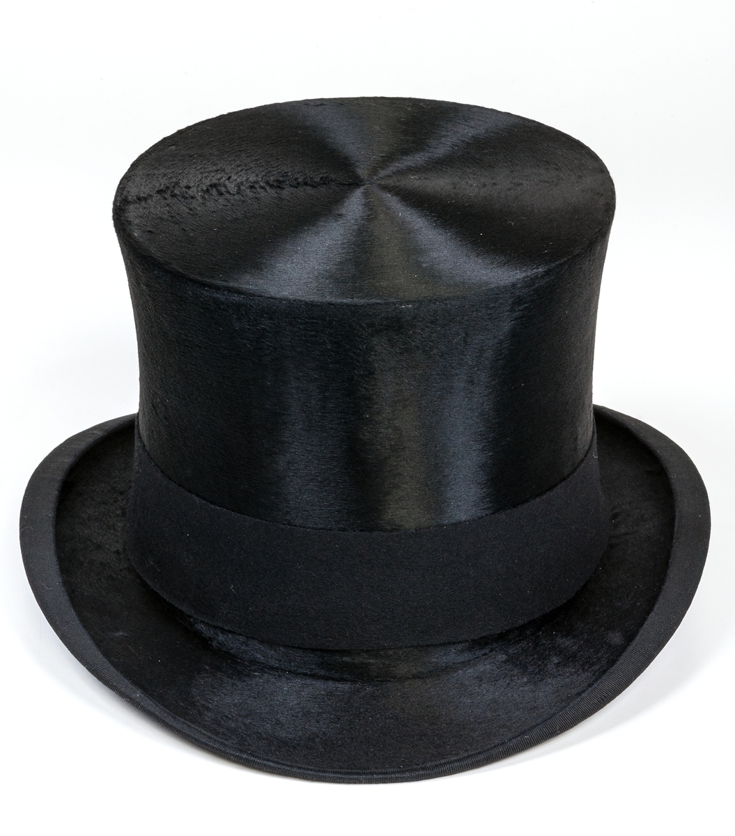 Hög hatt, svart., med tillhörande hattask.