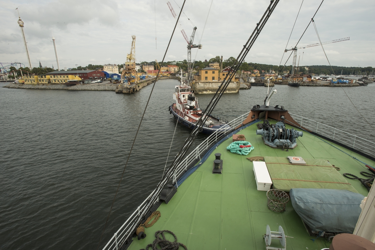 Isbrytaren Sankt Erik bogseras i  dockan på Beckholmens varv av bogserbåten M/S Leif för bottenöversyn och målning.