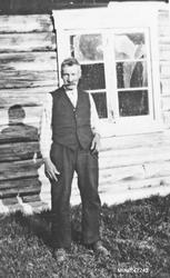 Eldre mann foran bolighus