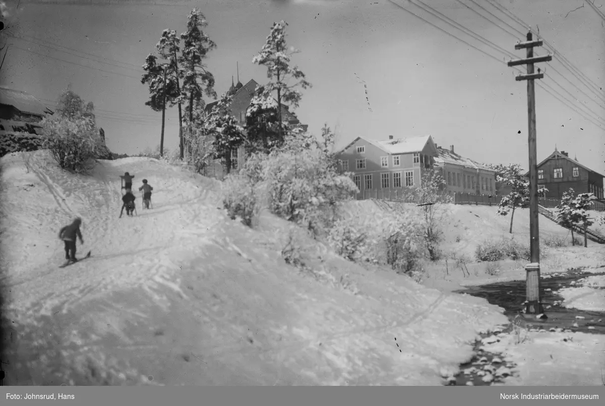 Barn på ski i Hvåladalen. Sentrumsskolen sees i bakgrunnen.