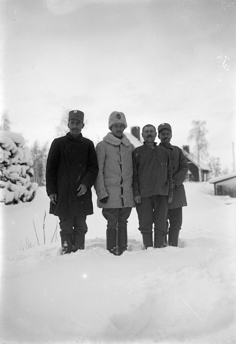 Röda korset, invalidutväxling 1915-1917 Fyra soldater stående på en snötäckt öppen plats.