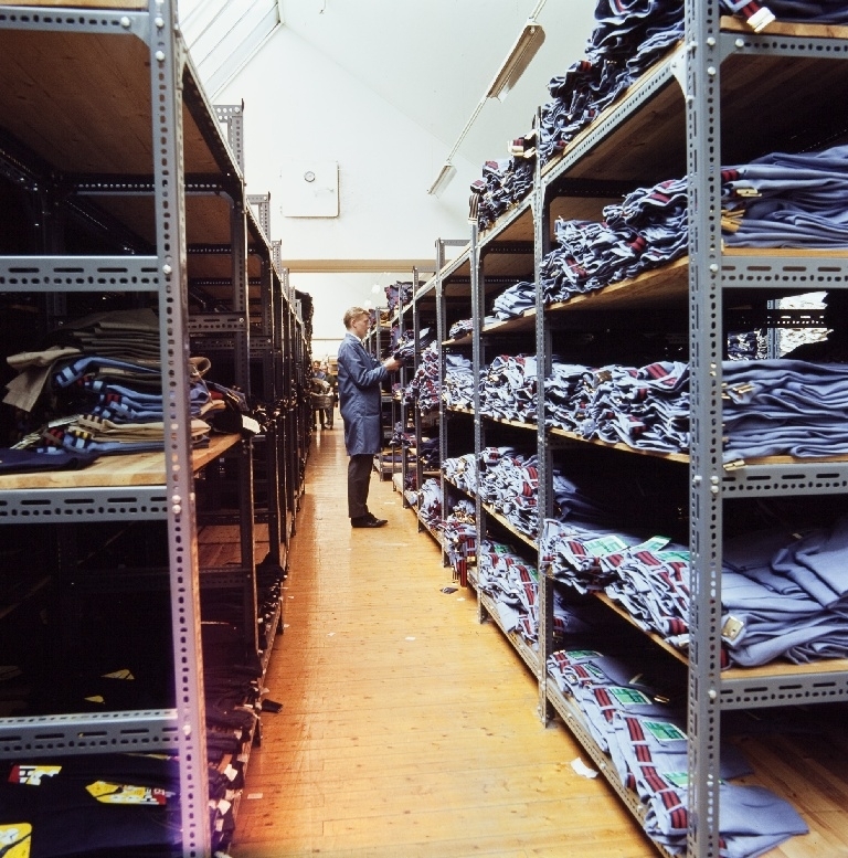 Mann mellom reolene i ferdiglageret for jeans i konfeksjonsfabrikken til Jonas Øglænd AS på Sandnes.