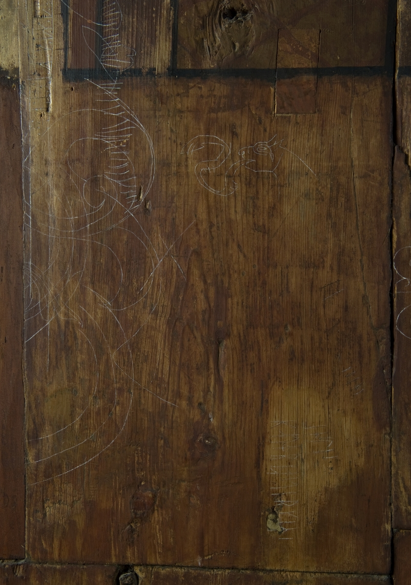 Innrissete bilder og runer på veggen i koret i Gol stavkirke på Norsk Folkemuseum.