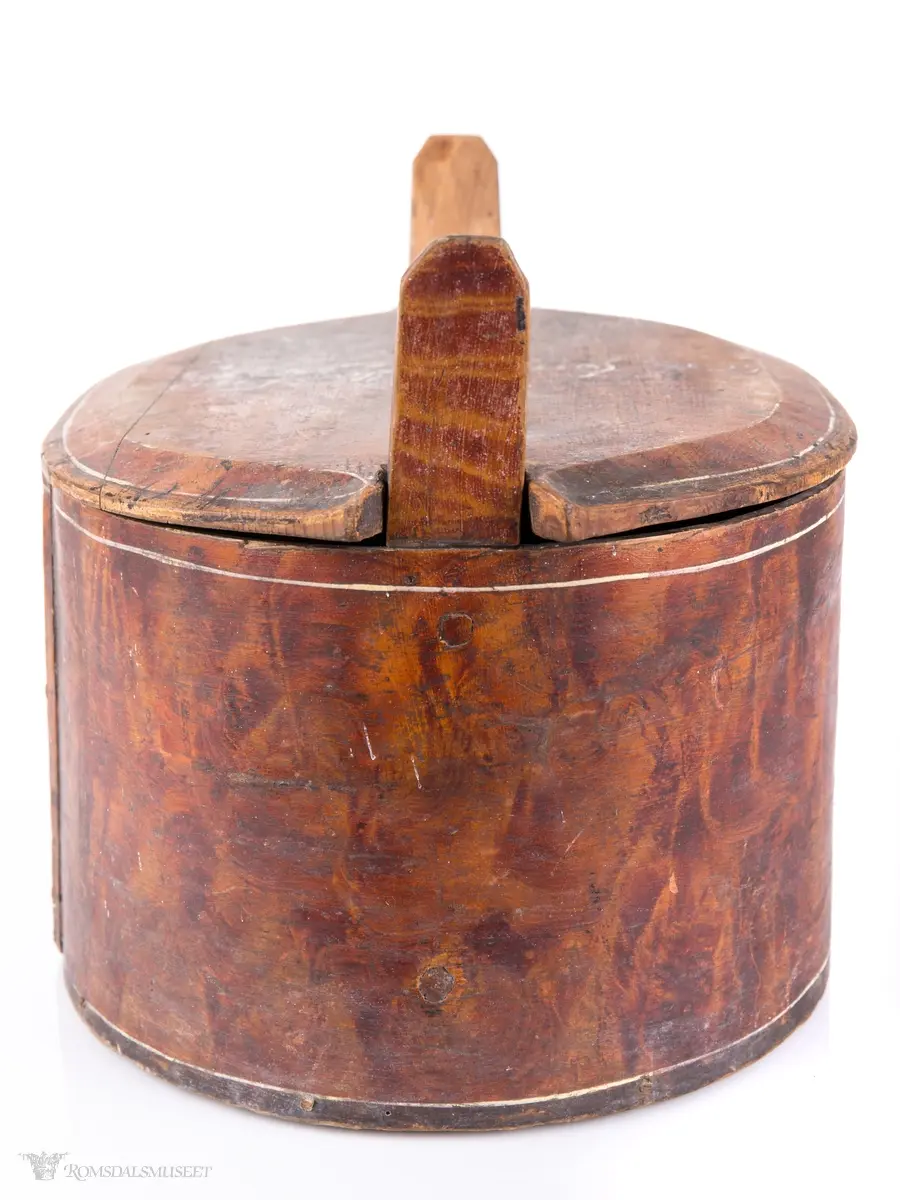 Hvite linjer langs kanten. Avrundet lokk. Innskrift.