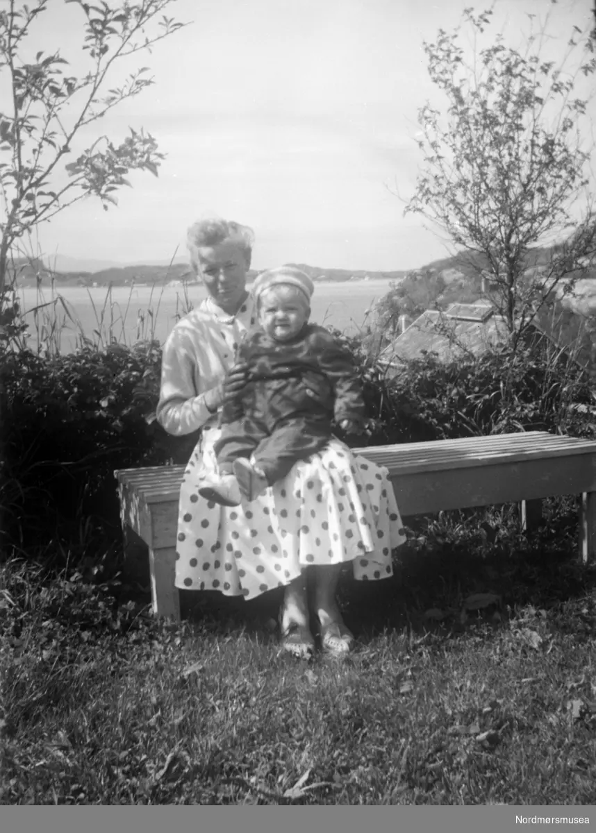 Kvinne (mor?) og barn. Vugga, Kristiansund? sommer, 1950-tall. Opplasta 17.11.2017. Fra familien Wågbø. Fra Nordmøre museums fotosamlinger.