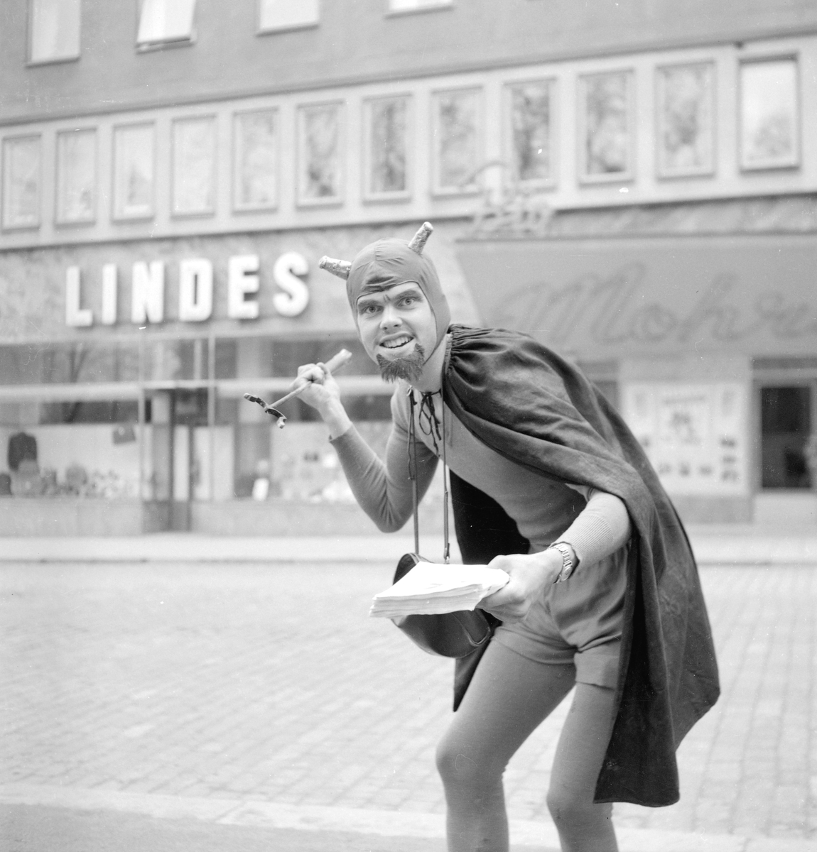 Motiv från 1950 års majkarneval i Linköping. På bilden har ondskans makt nått Storgatan i höjd med Lindes läderhandel och Mohriska biografen.