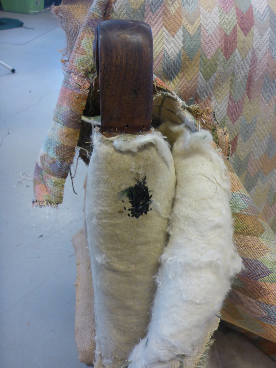 Stolen har en ramme av tre med dreide frambein som er beiset og oljet.