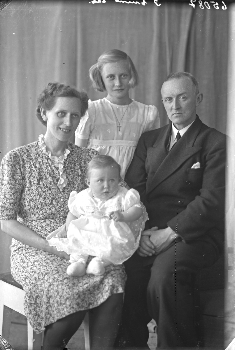 Gruppebilde. Familiegruppe på fire. Mor, far, en ung pike og et spebarn. Bestilt av John Olsen. Olav Kurresgt. 13.