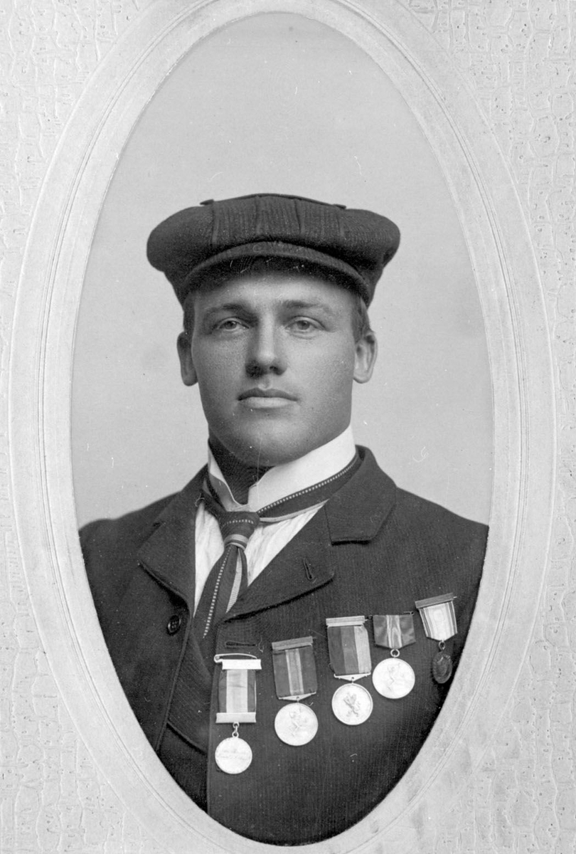 Ovalt brystbilde av Knut G. Helland i Amerika i 1906. Han har fem skimedaljer på brystet.