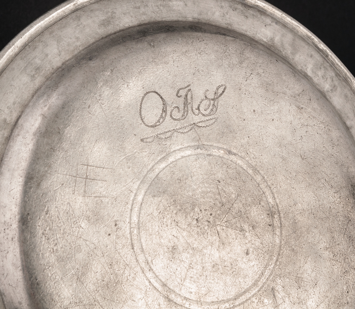 Tenntallrik, rund, på undersidan svisselerat "O.A.S." Diam 21 cm. 4 stämplar.