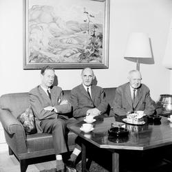 3 menn ved salongbord.