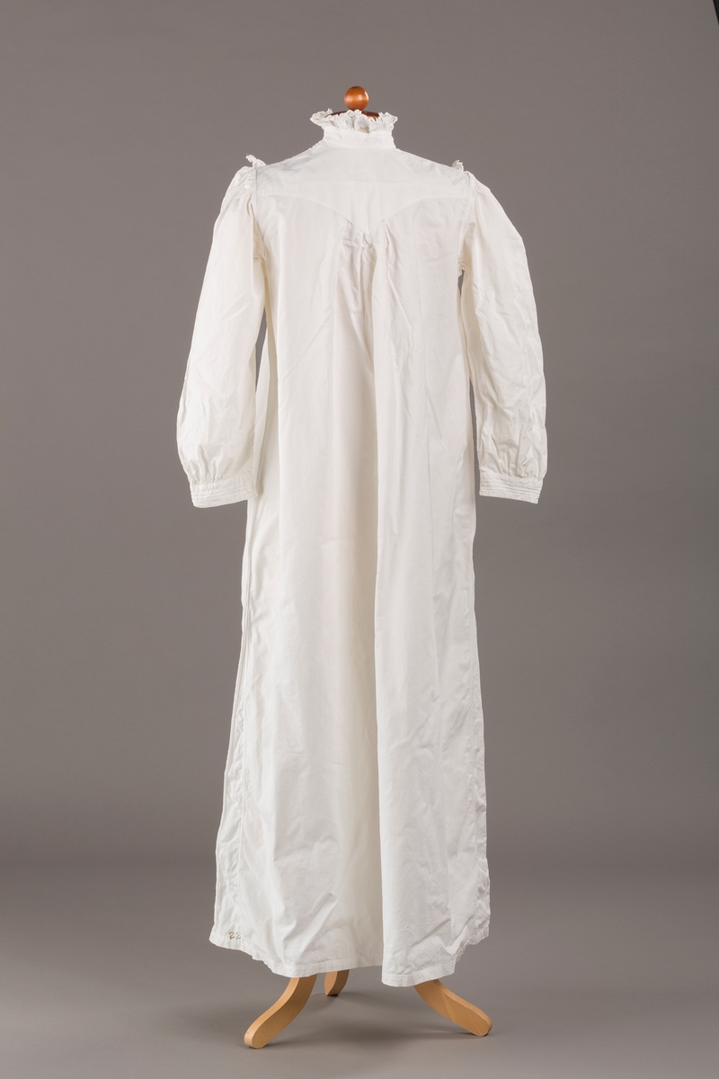 Form: Lange ermer, fotsid.

Blondekant og rysjer i halsåpning.
To knapper i metall kledd i tekstil. Mangler en knapp.