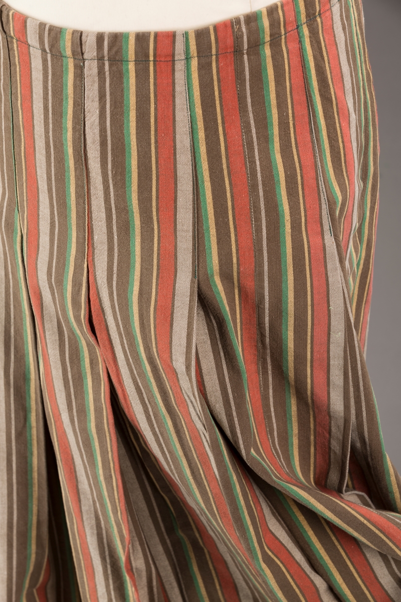 Stripete bomullsskjørt med nedsydde legg, uten linning, lukkes med trykknapper.