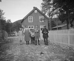 En kvinne, en mann i speideruniform, tre barn og en eldre ma