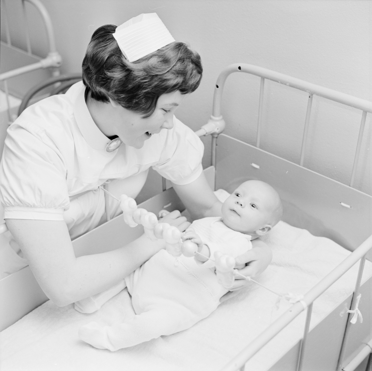 Barnsköterskan Lena Jansson tillsammans med ett spädbarn på Gillbergska barnhemmet, Sysslomansgatan 37