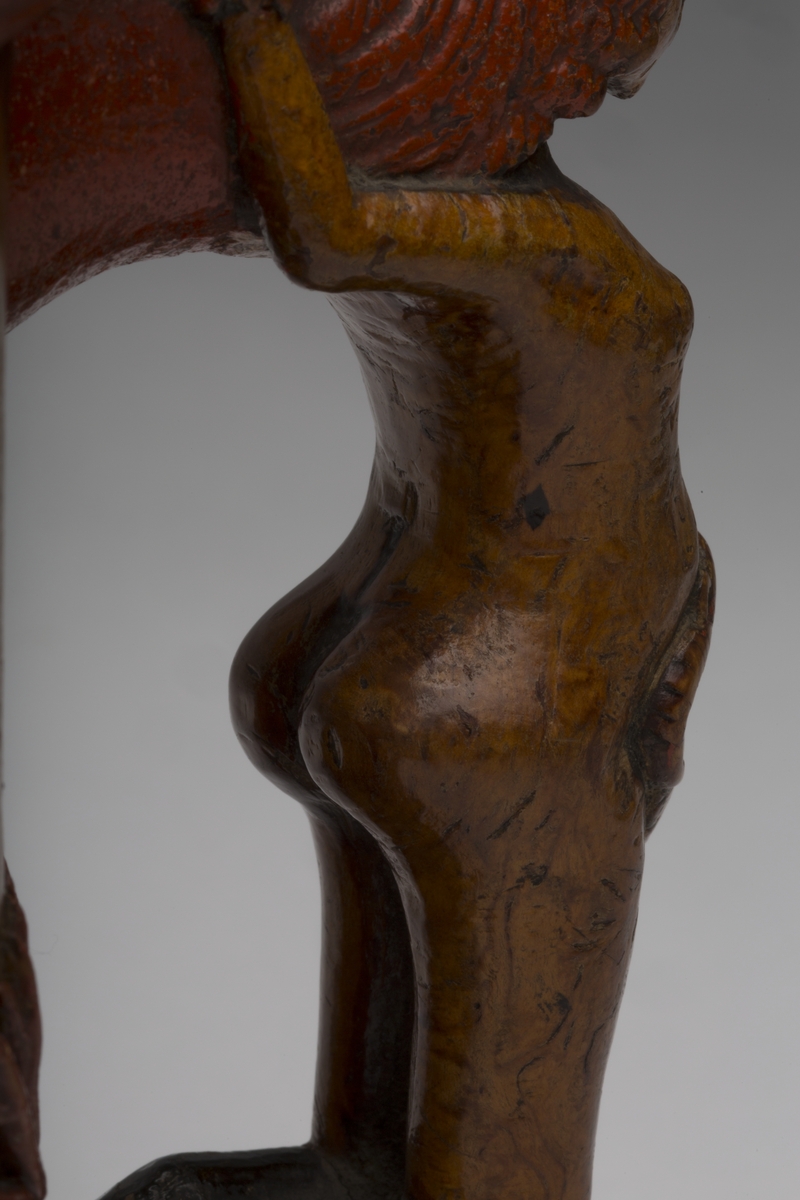 Dekorert med fortløpende billedfrise med dyr og trær på nederste del av korpus. Kannen har løveføtter og løvegjekk og bakkantine som håndtak. 