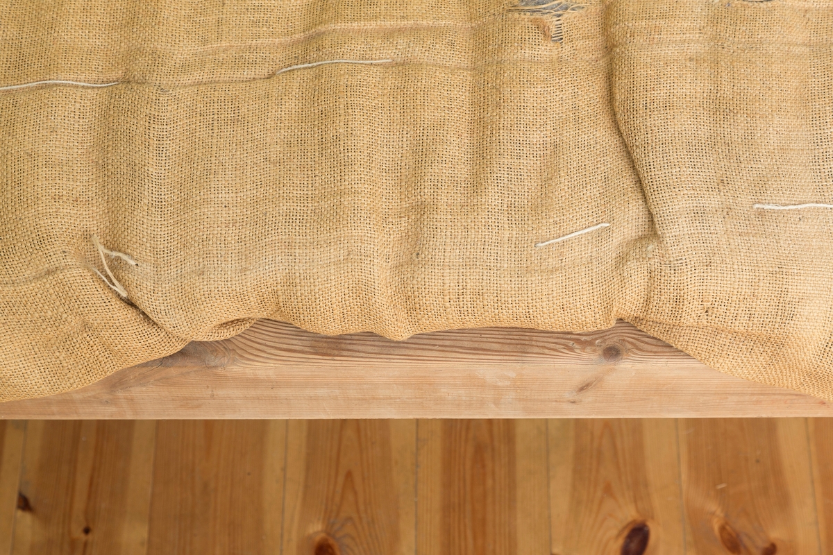 Sengeramme med sangegavler bestående av staver. Ubehandlet tre. Avstivere i metall. Nettingbunn.