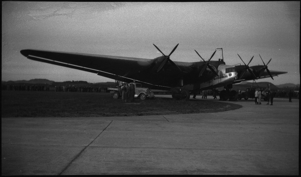 Bilder fra åpningen av den sivile flyplassen på Sømmesletta på Sola. Bildene viser folk som titter på flyene og helikoptrene som besøkte flyplassen fra inn- og utland i anledning åpningen. Det er flere bilder fra et stort passasjerfly fra Lufthansa med påskriften "Generalfeldmarschall von Hindenburg" og "D-APIS". Det er også et bilde fra en kanonbåt.