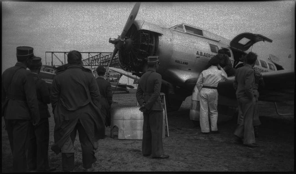 Bilder fra åpningen av den sivile flyplassen på Sømmesletta på Sola. Bildene viser folk som titter på flyene og helikoptrene som besøkte flyplassen fra inn- og utland i anledning åpningen. Det er flere bilder fra et stort passasjerfly fra Lufthansa med påskriften "Generalfeldmarschall von Hindenburg" og "D-APIS". Det er også et bilde fra en kanonbåt.