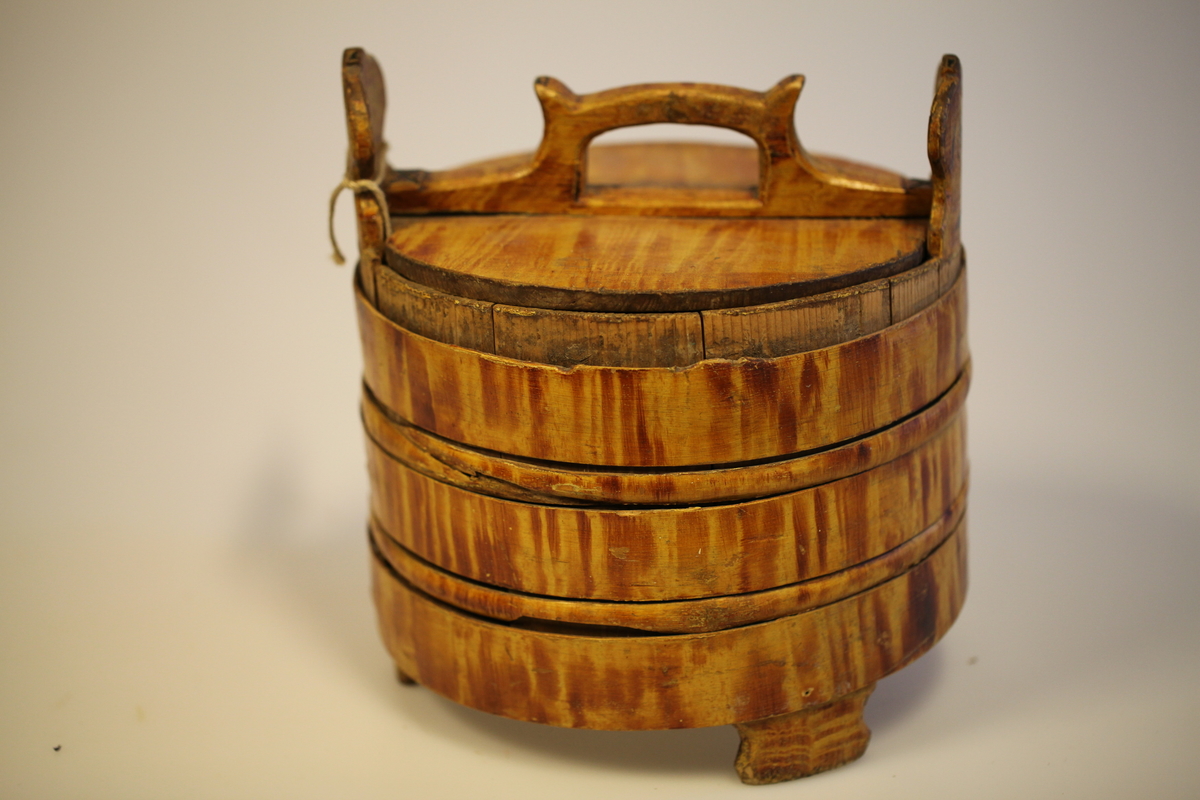 Lagging belagt med tette sveiperinger. Lokk, to ører  og tre bein. Formen er rund, lokk er nedfelt og har avlang hank. Sveip med skjøter (5 stk.) (gjorder). Påmalt gyllengul farge, ådringsmalt.