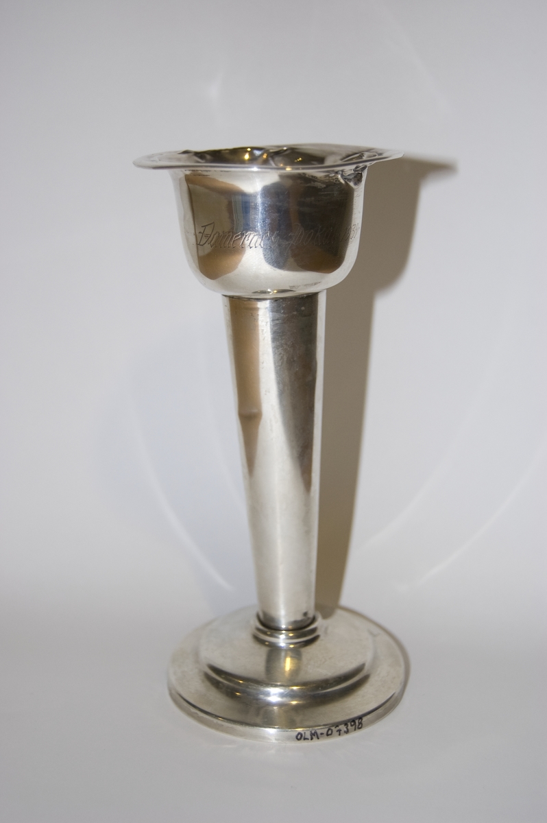 Pokal av sølv. Den er noe slitt.