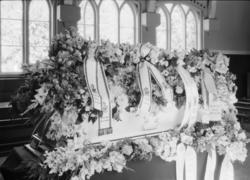 Begravelse fra Lillehammer kapell. Blomsterdekket kiste med 