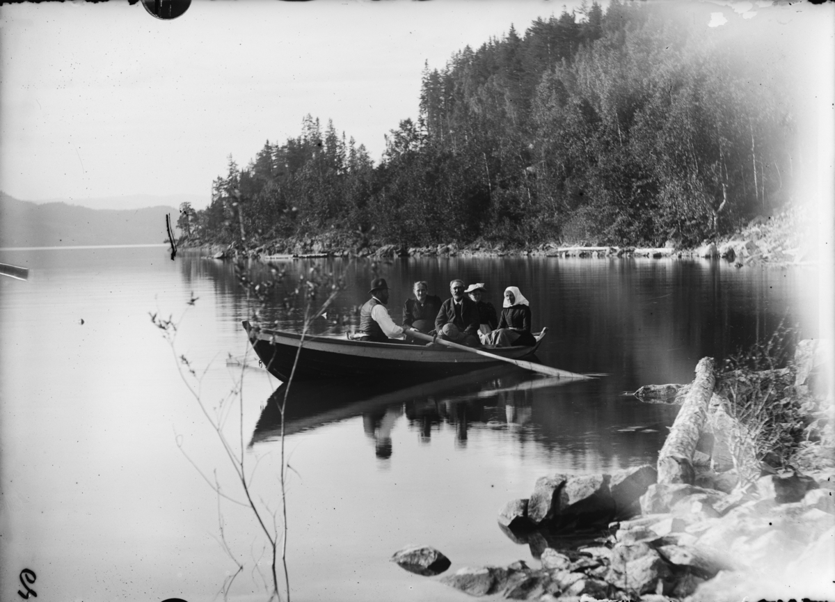 Fem personer i en robåt langs Bergseng-landet