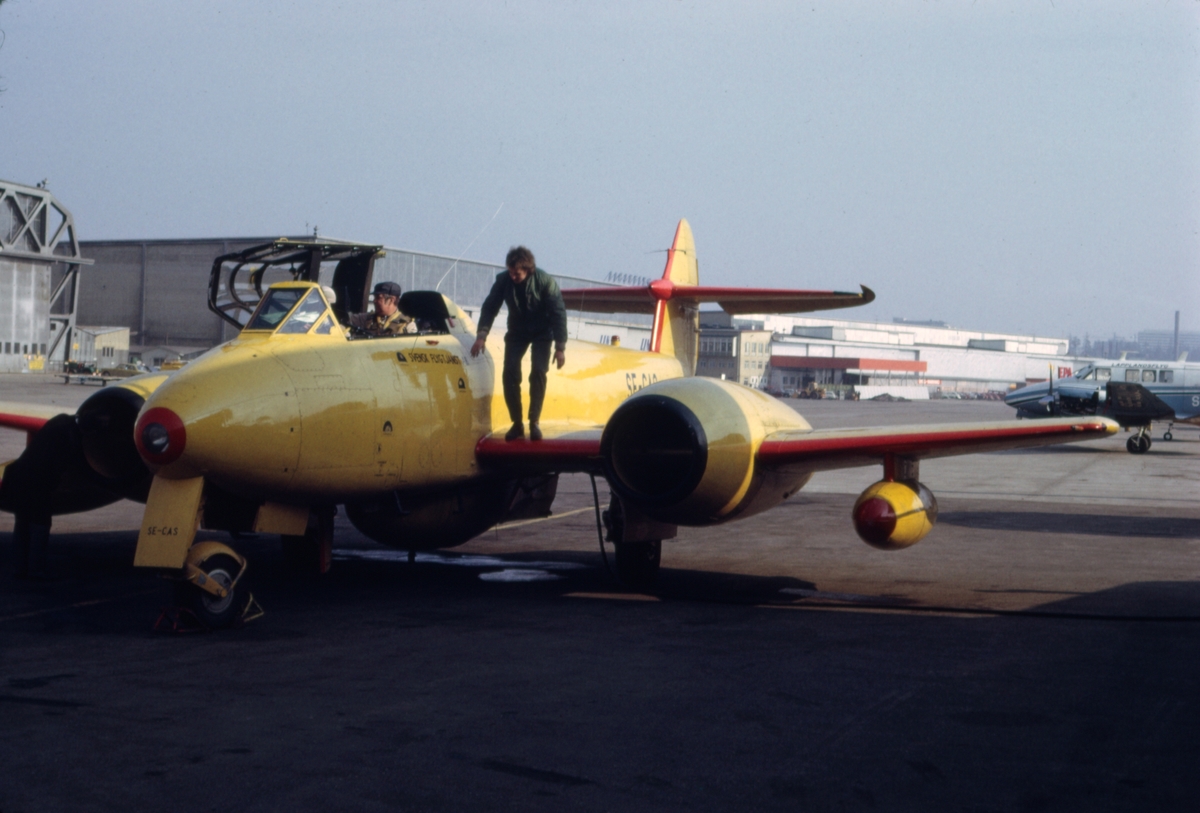 Gulmålat målbogserflygplan av typ Gloster Meteor T.7 med civilt registreringsnummer SE-CAS på Bromma flygplats, i början av 1970-talet. Flygförare och flygtekniker i arbete. Serie om 7 bilder.