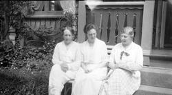 Rebekka, Elisabeth og Hilda Sundt sitter på trappen utenfor 