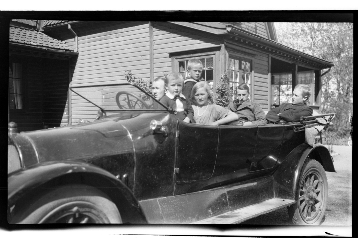 En ukjent person, Julius Sundt, Bjarne Halfdannssøn Sundt, Julie Cecilie (Essemor) Sundt og to ukjente personer sitter i Rolf Sundts sr. Dodge, Stavern. Fotografert 1920.