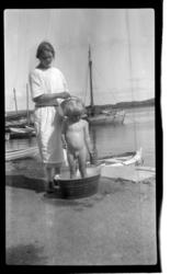 Rolf Sundt Jr. vaskes i sinkbalje av ukjent kvinne ved båtha