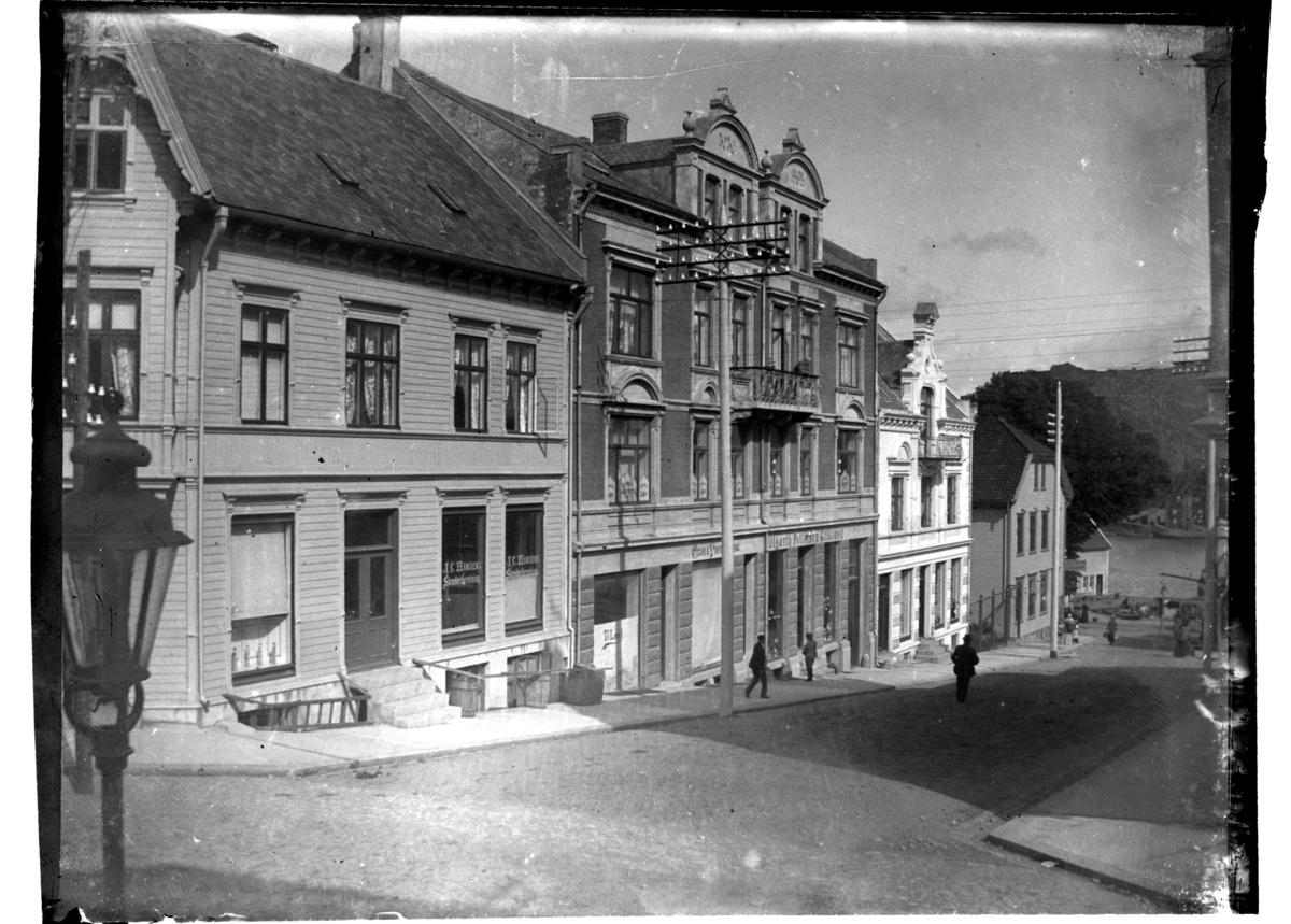 Forskjellige bygninger ligger i Kirkegaten som munner ut i sjøen, Farsund. Fotografert 1903.