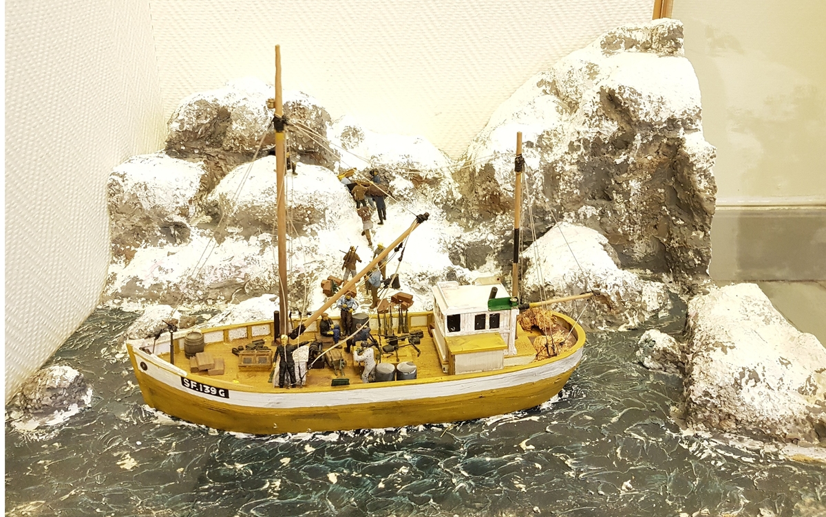 Modell i gips og tre av Håkon Furnes sin båt "Sleipner" montert med landskap og mennesker om bord i båten.
