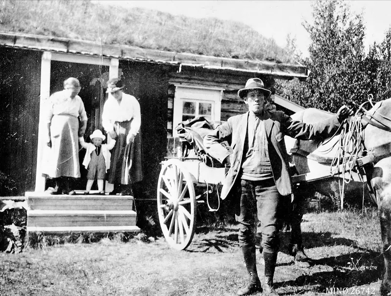 Seter. Mann med hest og kjerre. Kvinner og barn i døråpningen på seterstuen